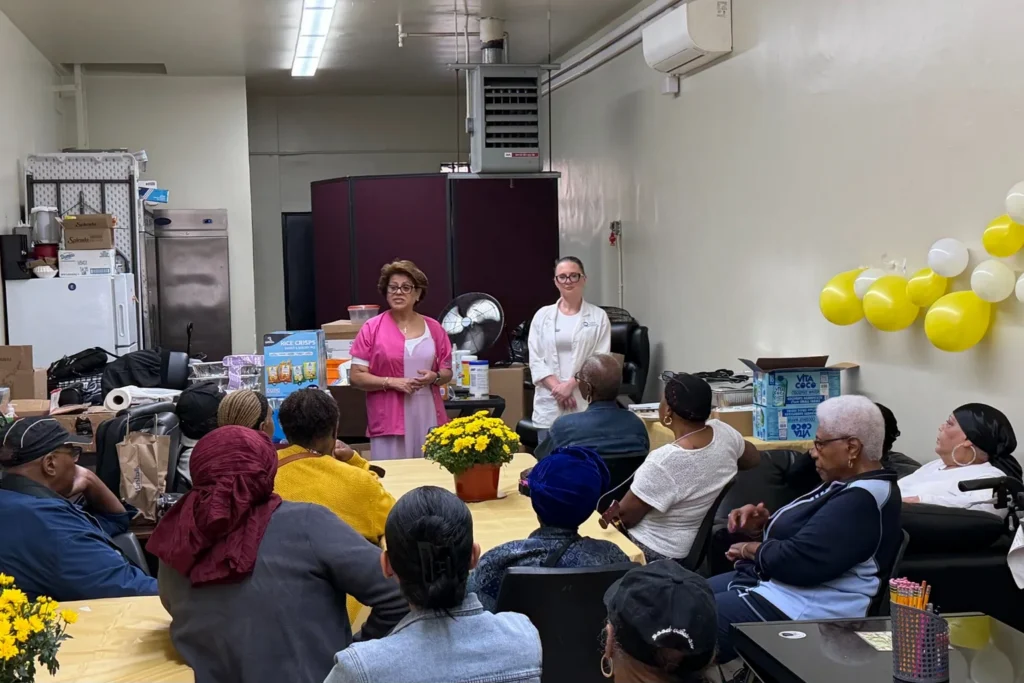 Maribel speaks with Taft residents while Anna Kelmenson stands beside her during a Preferred Pharmacy health education presentation in East Harlem.